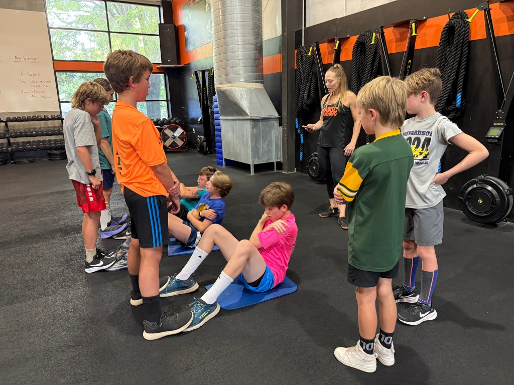Manic Training Fort Collins kids helping each other do sit ups and other exercises