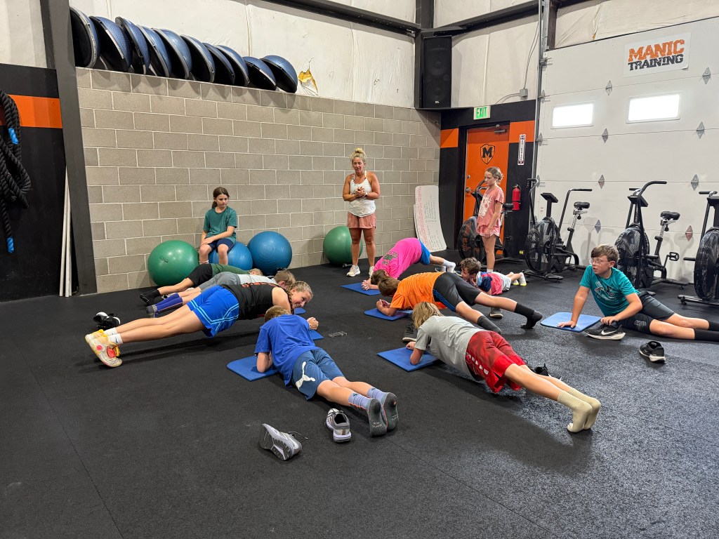 Group of Manic Training kids holding a plank for competition